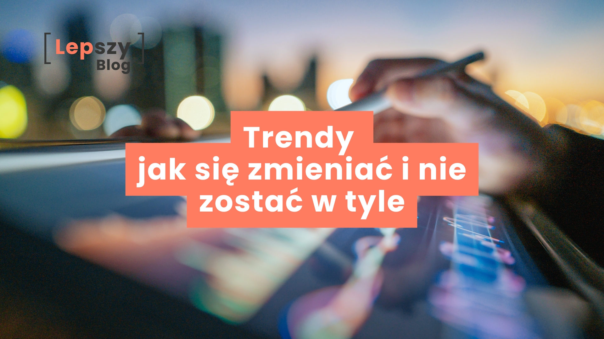 Ręka pisząca rysikiem po tablecie z kolorowymi, rozmytymi wykresami – napis „Trendy – jak się zmieniać i nie zostać w tyle”, symbol ciągłego uczenia się i podążania za zmianami w świecie twórczości online.