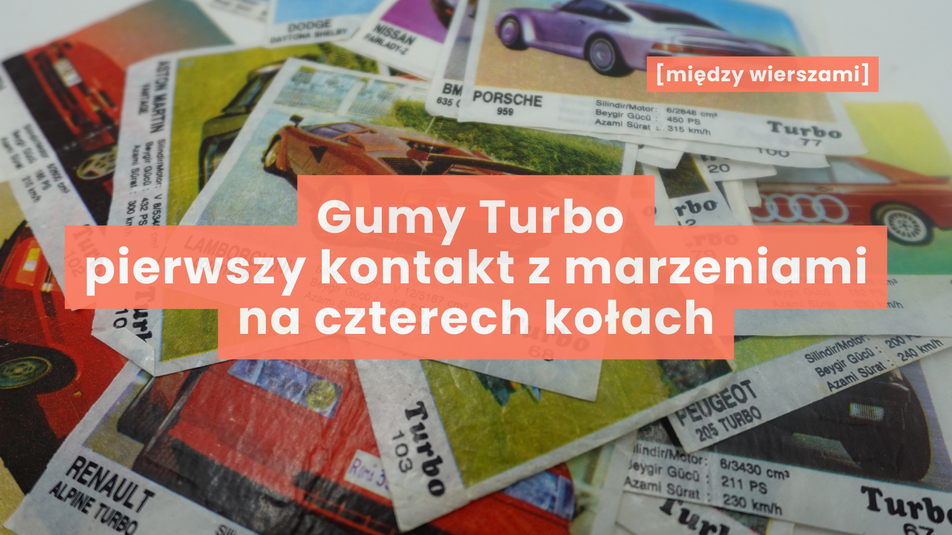 Na stole rozłożone są kolorowe papierki z gum Turbo, z fotografiami legendarnych samochodów (m.in. Porsche, Peugeot, Aston Martin) i krótkimi opisami technicznymi – napis „Gumy Turbo. Pierwszy kontakt z marzeniami na czterech kołach”, symbol dziecięcej fascynacji motoryzacją, wyobraźni i pierwszych marzeń budowanych z obrazów, zanim stały się realnym doświadczeniem.